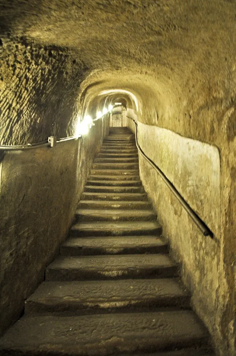 Eine schmale beleuchtete Treppe in Napoli Sotterranea