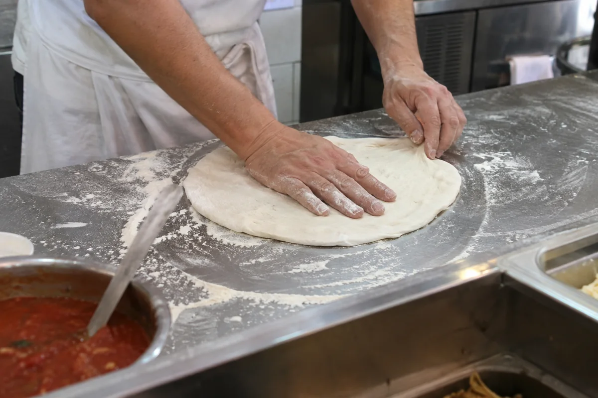 Pizzateig bei einem Kochkurs vorbereiten